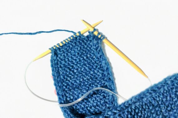 まずは3目表編みする。それから4番目をすべり目にして右の針へ移動させ、5番目は普通に表編みを編む。(※すべり目は表編みを編むのと同じ方向から針を入れる。)左の針で4番目を引っ掛けて5番目にかぶせるようにして入れ替え、針からはずすと右の針に掛かっていた5目が4目になる。